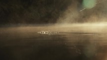 Young fly fisherman casting on a foggy river at sunrise