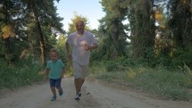 Grandfather and grandson jogging in the forest