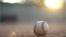 baseball on a baseball field at sunset 