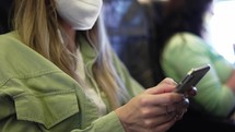 Woman travel tourist in white respirator using mobile at the airplane, close up.