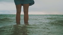 legs standing in ocean water 