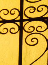 shadows from a wrought iron fence 