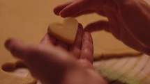 Young woman cutting and examining heart shaped valentines day cookies