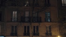 PARIS, FRANCE -  Exterior of a house, view at night in dim light of the lantern. People can be seen in the windows