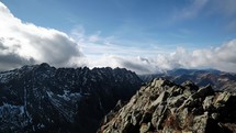 Time-lapse video of impressive rock walls. Clouds above the peaks of mountain peaks.