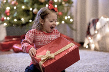 a girl opening a Christmas gift 