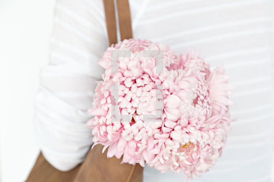 a woman carrying pink flowers in her purse 