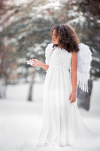 a girl dressed as an angel in the snow 