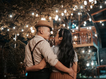 a couple on a date embracing outdoors at night 