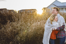 portrait of a couple wrapped in a blanket outdoors 