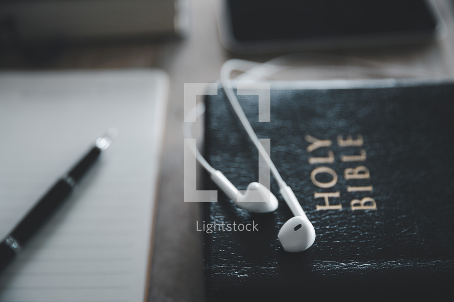 Earbuds and a notebook with a Bible