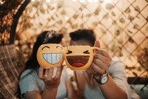 couple holding up smiley face mugs 