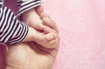 newborn feet in cupped hands 