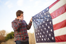Man holding an American flag and crying 