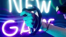 Close up of an arm holding a joystick while playing a virtual reality game.