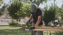 Man using a jig saw to cut through wood in slow motion