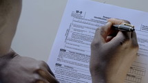 a man filling out tax forms for employment 