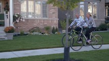 a couple riding bikes in a neighborhood 