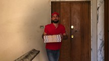 Smiling pizza delivery man delivering pizza boxes