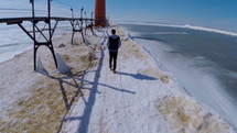 a guy walking on a pier covered by snow 