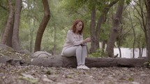 a woman praying and reading a Bible in a park 