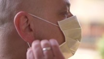 a man removing a surgical mask 