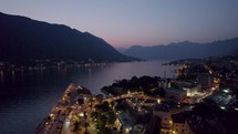 Drone flyover Kotor bay cityscape during mystic sunset, Montenegro