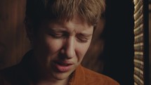 Young regretful woman crying and talking to priest emotionally during confession in church. Close-up shot
