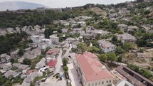 Aerial over Gjirokastër city with Gjirokastra Fortress on hillside, Albania
