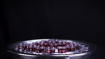 Communion glass cups on tray filled with wine the symbol of Jesus Christ blood on black background. 