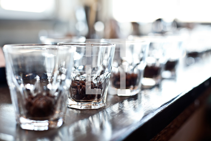 coffee beans in a row of glasses