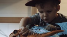 toddler boy playing with dragons and dinosaurs 