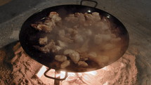 Chickens sizzling on a giant paella pan in Valencia, Spain