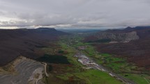 Forward-moving cinematic drone shot over a highway through a valley in the Basque Country, Spain, with mountainous and forested landscape