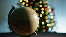 Santa Pointing On Globe Against Christmas Tree