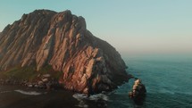 drone view of huge rock in the ocean in morro bay