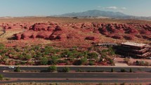 drone fly reveals street with red rocks in st. george utah