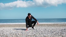 Gymnic Boy Does Stretching On The Beach Near The Ocean