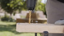 Close up of a drill making a hole in a piece of wood - slow motion