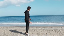 Boy Throws Stones Into Ocean To Make Them Jump