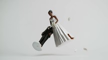 two wedding figurines falling and breaking apart.