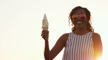 a woman holding up an ice cream cone 