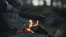 a man cooking in a forest 