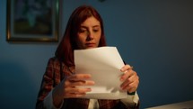 Young woman opens and reads a letter