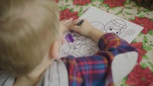 a child coloring a Christmas coloring page 