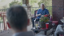 men sitting on a porch talking 