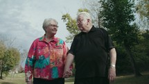 elderly couple walking holding hands 