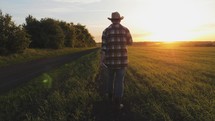farmer walk on the field at sunset