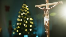 Christ Crucifix with Christmas tree in the background 