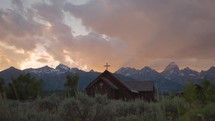 Old Wooden Chapel in the Mountains at Sunset